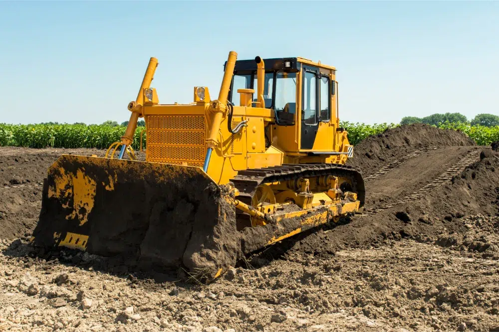 Land Clearing Equipment: What The Pros Use & Why 2 yellow bulldozer with crawler tractor standing field land clearing equipment