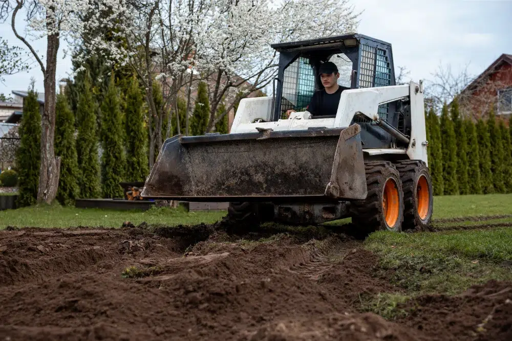 young professional operating land clearing equipment on residential site young professional operating land clearing equipment on residential site